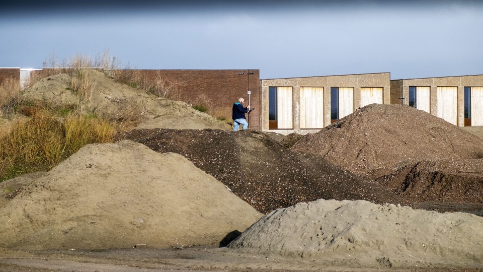 Een landmeter aan het werk in de wijk Rotterdam-Kralingen.