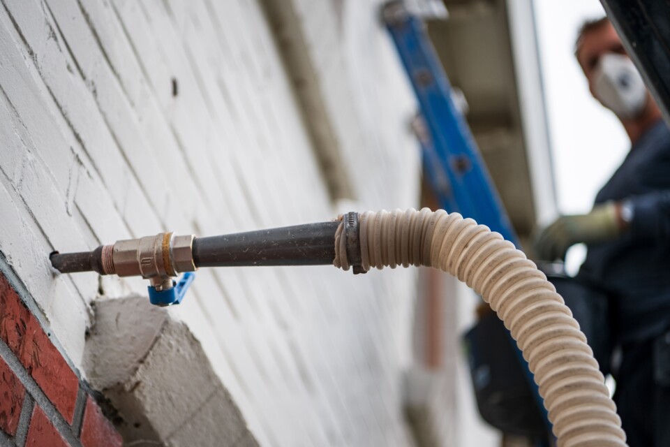 Een isoleerbedrijf brengt gevelisolatie aan in een woning, in Sappermeer in de provincie Groningen.